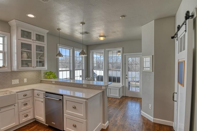 kitchen with a barn door, kitchen peninsula, and white cabinets