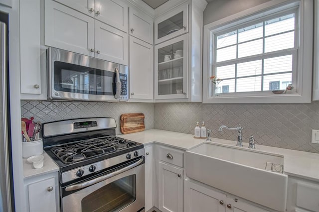 kitchen with stainless steel appliances, sink, and white cabinets