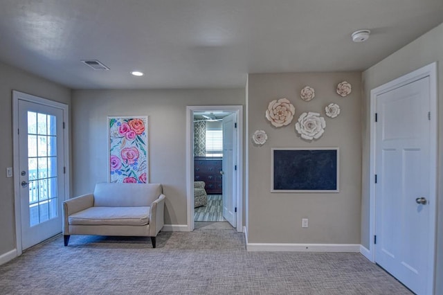 sitting room featuring light carpet and plenty of natural light