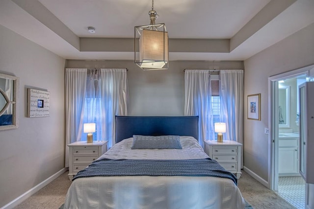 carpeted bedroom with a raised ceiling