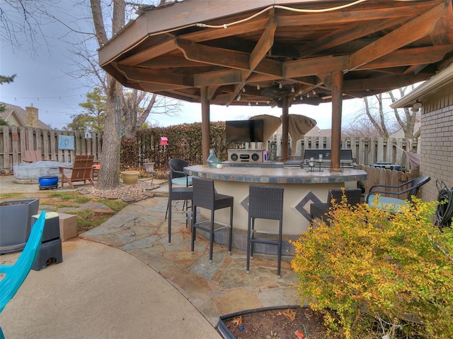 view of patio with a bar, a grill, a gazebo, and an outdoor kitchen