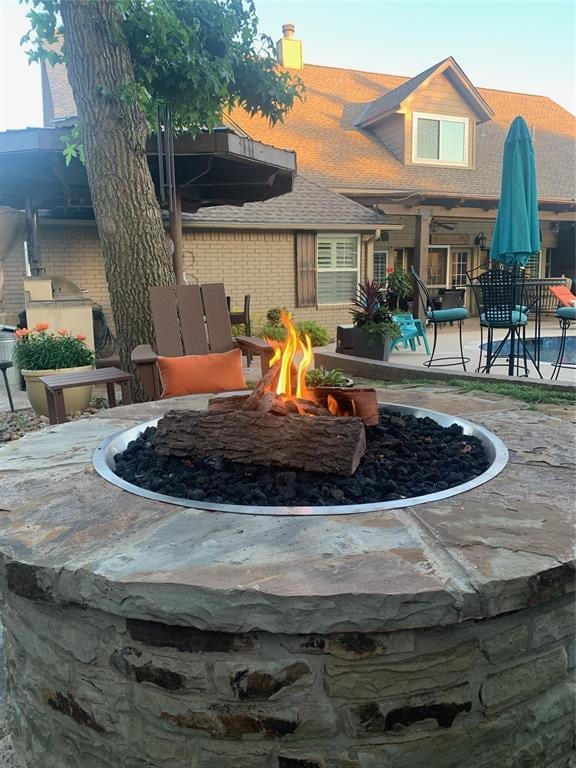 surrounding community featuring area for grilling, a patio area, and a fire pit