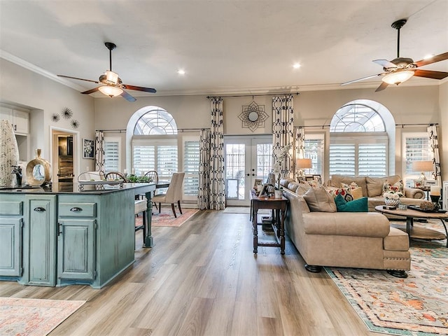 living room featuring light hardwood / wood-style flooring, ornamental molding, french doors, and ceiling fan