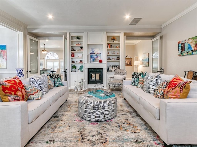 living room with crown molding and built in shelves