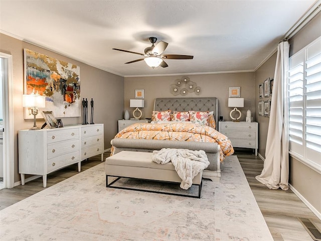 bedroom with ornamental molding, wood-type flooring, and ceiling fan