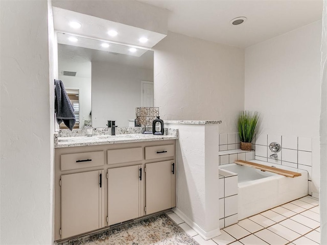 bathroom with vanity, tile patterned flooring, and a washtub