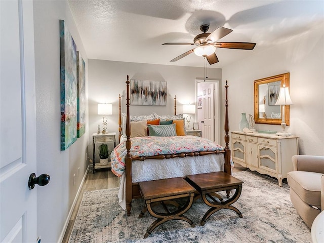 bedroom with ceiling fan, light hardwood / wood-style flooring, and a textured ceiling