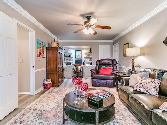 living room with ceiling fan, ornamental molding, built in desk, and light hardwood / wood-style floors