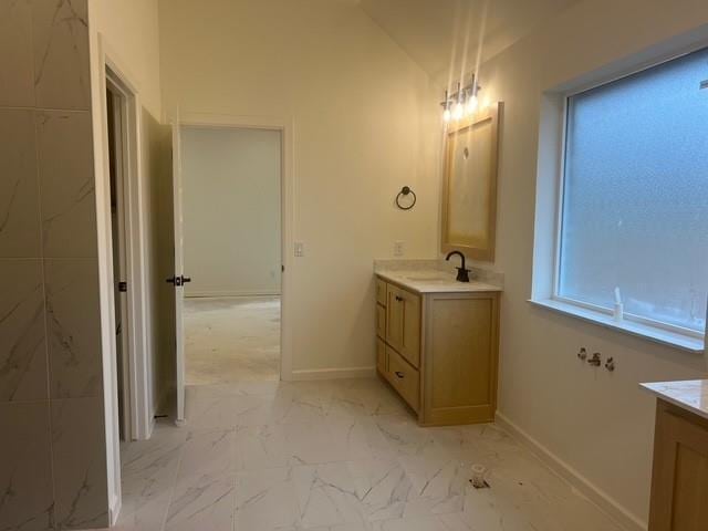 bathroom with lofted ceiling and vanity