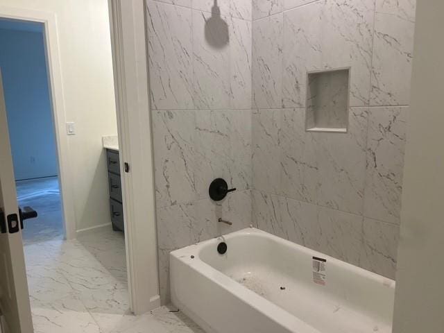 bathroom with tiled shower / bath and vanity