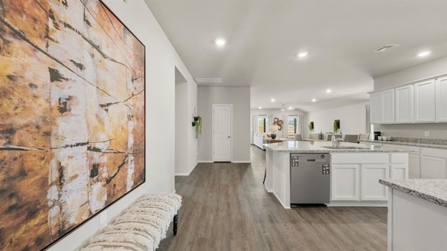 kitchen featuring white cabinetry, dishwasher, light stone counters, and light hardwood / wood-style flooring