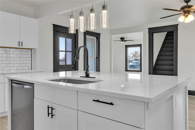 kitchen with white cabinetry, sink, light stone counters, and dishwasher