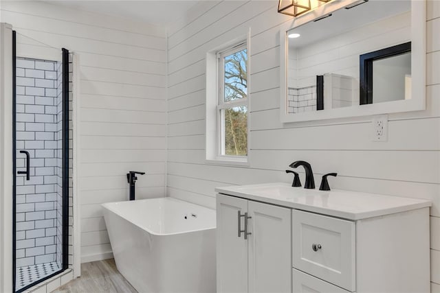 bathroom with independent shower and bath, vanity, hardwood / wood-style flooring, and wood walls