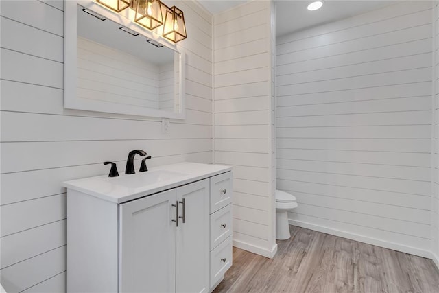 bathroom featuring vanity, toilet, and hardwood / wood-style floors