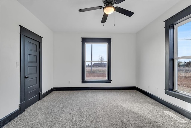 unfurnished room featuring dark colored carpet and ceiling fan