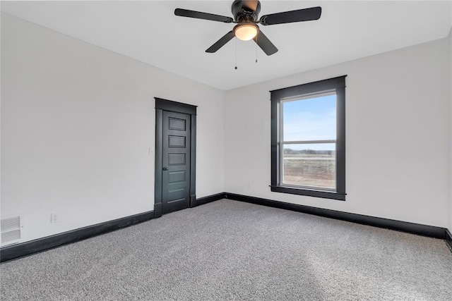 carpeted spare room featuring ceiling fan