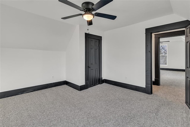 interior space with light carpet, vaulted ceiling, and ceiling fan