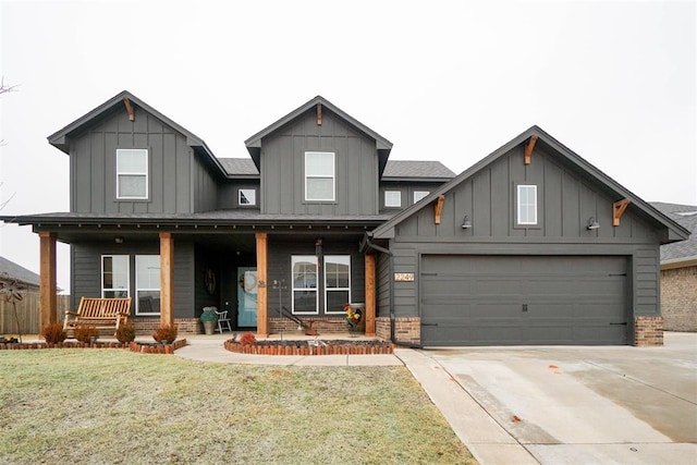 view of front of property with a porch, a garage, and a front yard