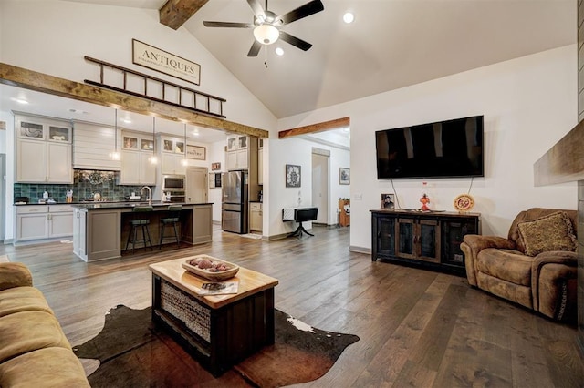 living room featuring hardwood / wood-style flooring, high vaulted ceiling, sink, and beam ceiling