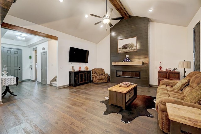 living room featuring wood-type flooring, high vaulted ceiling, beamed ceiling, ceiling fan, and a fireplace