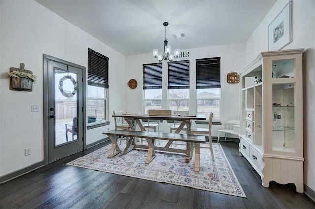 dining space with dark hardwood / wood-style flooring and a chandelier