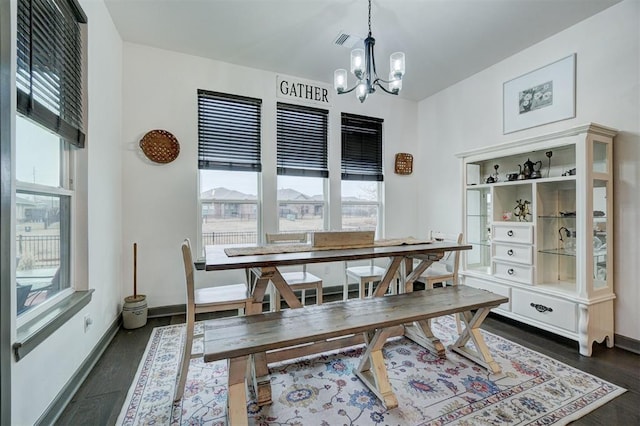 dining room featuring dark hardwood / wood-style flooring, a notable chandelier, and a wealth of natural light