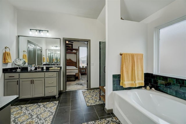 bathroom featuring tile patterned flooring, vanity, lofted ceiling, and independent shower and bath