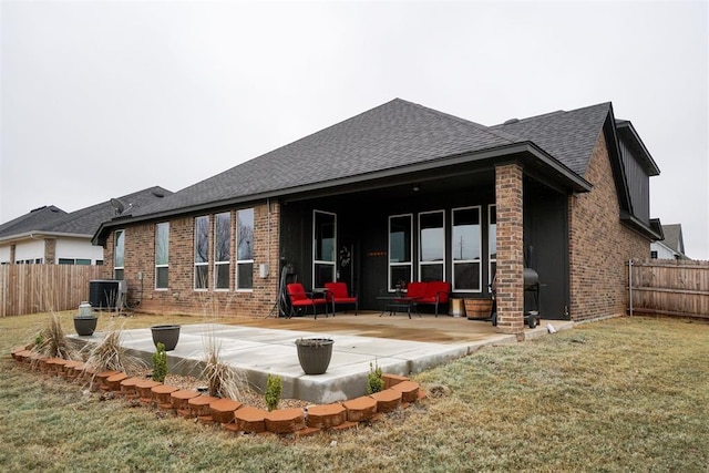 rear view of house featuring a yard, central AC, and a patio