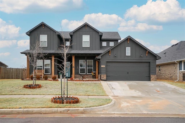 view of front of house with board and batten siding, a front lawn, fence, a porch, and concrete driveway