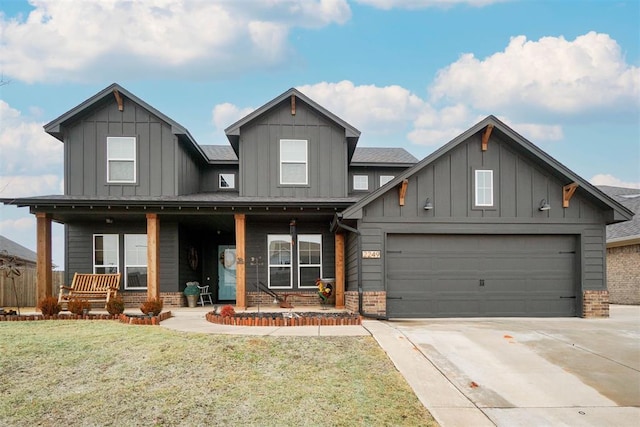 view of front of house featuring driveway, a porch, a front lawn, board and batten siding, and brick siding