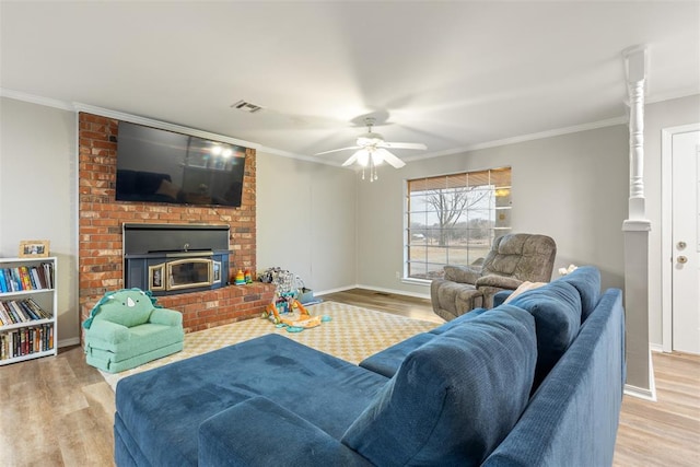 living room featuring ornamental molding, ceiling fan, and light wood-type flooring