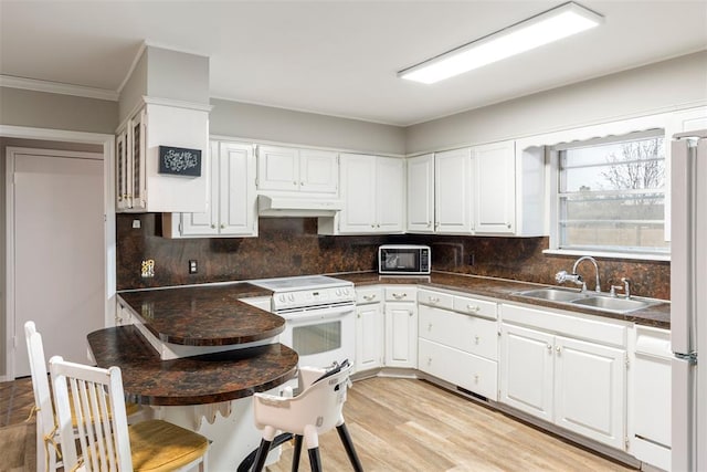 kitchen featuring white range with electric stovetop, sink, white cabinets, decorative backsplash, and light wood-type flooring