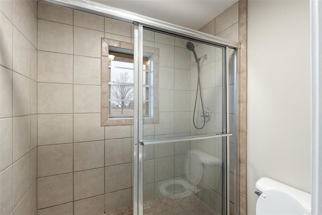 bathroom with an enclosed shower and toilet