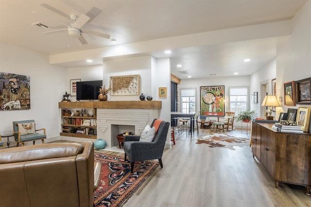 living room featuring light hardwood / wood-style flooring and ceiling fan