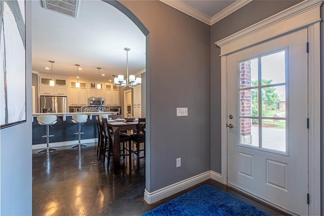 entryway with a notable chandelier and ornamental molding