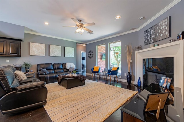 living room with hardwood / wood-style floors, ornamental molding, and ceiling fan