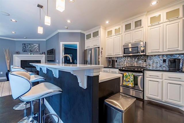 kitchen featuring pendant lighting, tasteful backsplash, white cabinets, and appliances with stainless steel finishes