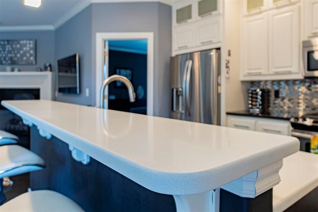 kitchen featuring ornamental molding, white cabinets, backsplash, and stainless steel fridge with ice dispenser