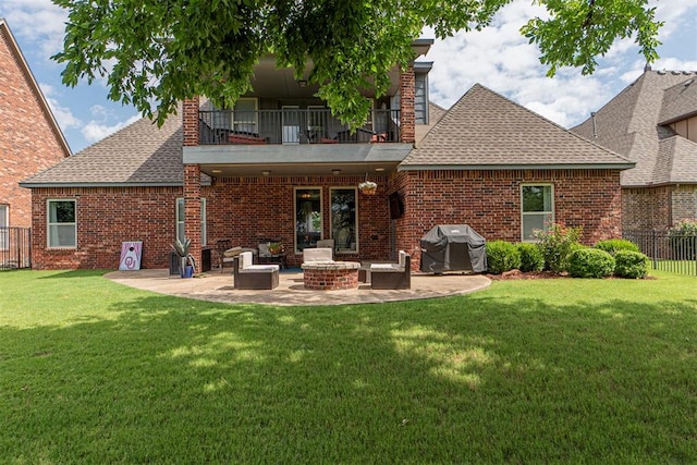 rear view of house featuring a balcony, an outdoor fire pit, a patio, and a lawn