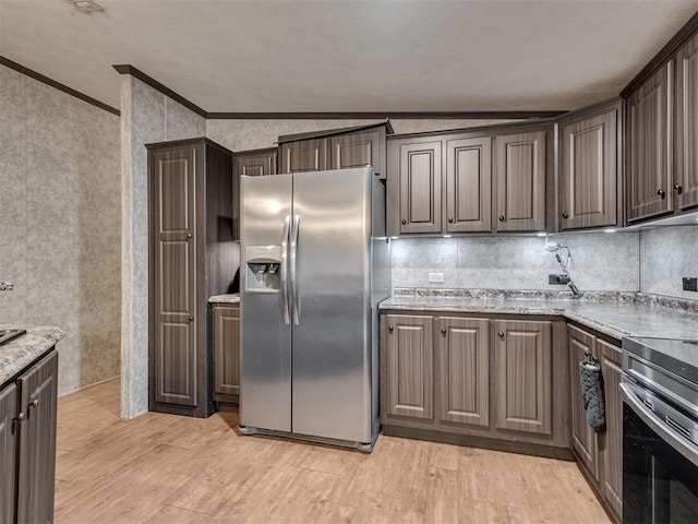 kitchen featuring appliances with stainless steel finishes, light wood-type flooring, dark brown cabinetry, and ornamental molding