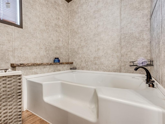 full bathroom featuring wood finished floors and a bath