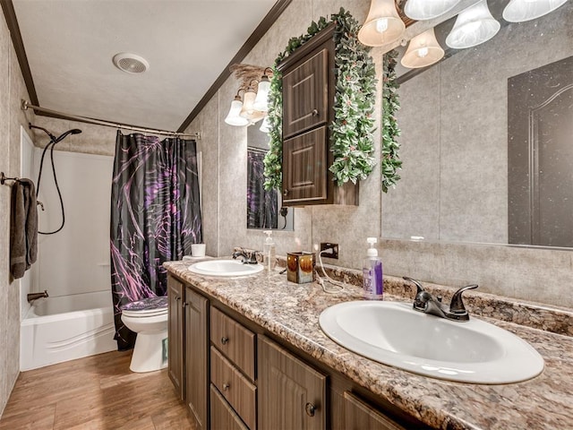 bathroom featuring toilet, a sink, shower / bath combo with shower curtain, and crown molding