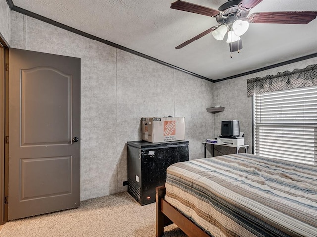 bedroom featuring ornamental molding, light colored carpet, ceiling fan, and a textured ceiling