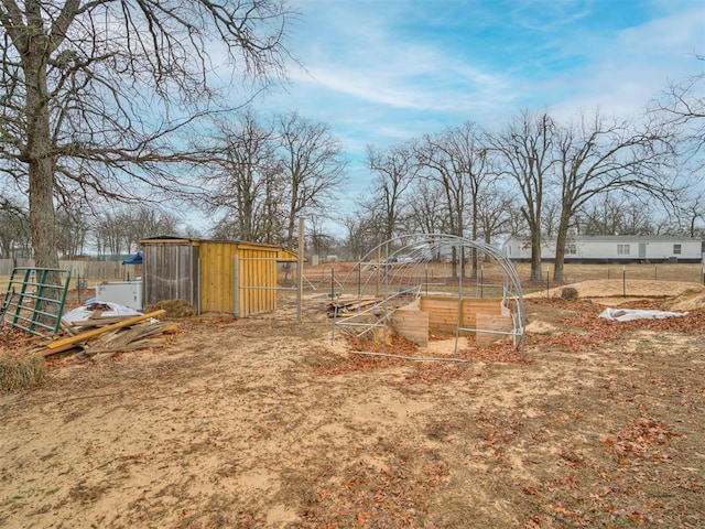 view of yard with an outdoor structure, fence, and exterior structure
