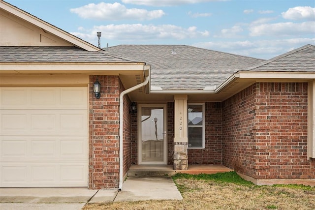4220 Red Apple Ter, Moore, OK 73160 - property entrance with a shingled roof, brick siding, and an attached garage