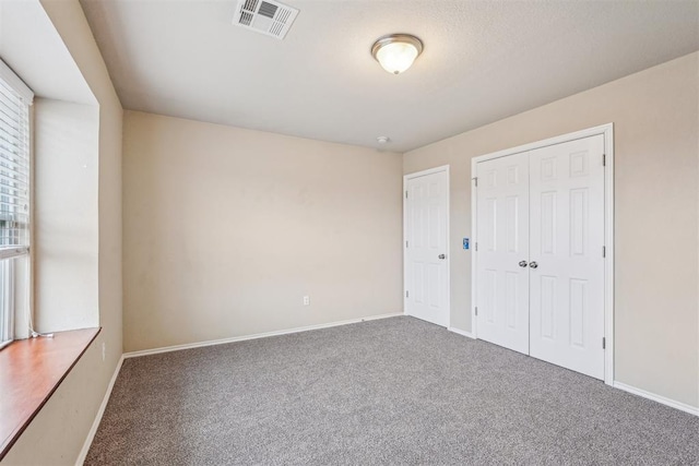 unfurnished bedroom featuring carpet floors and a closet