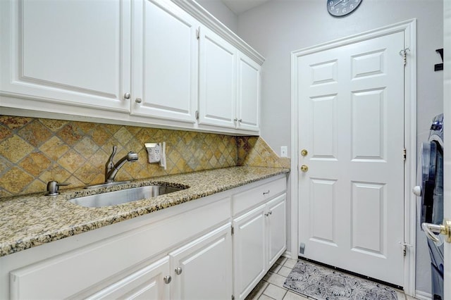 laundry area with cabinets, light tile patterned flooring, and sink