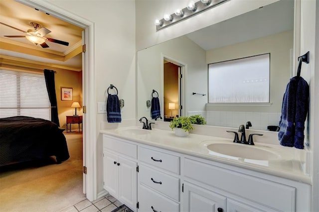 bathroom with tile patterned floors, crown molding, vanity, a raised ceiling, and ceiling fan