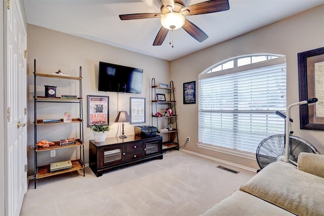 living area with light colored carpet and ceiling fan