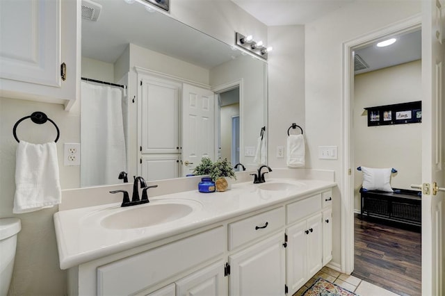 bathroom featuring tile patterned flooring, vanity, and toilet